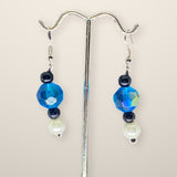 Blue Black Earrings - beaded drop earrings on hooks, shown on a silver stand