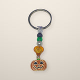 Pumpkin and Green Charm Keychain with a smiling jack-o-lantern charm, orange heart, green and pearl beads on a silver ring