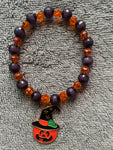 Black and orange shiny beads with dangling Halloween pumpkin with a hat charm