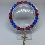 Blue and red bracelet with dangling shiny cross