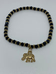 Black and gold bracelet with dangling gold elephant