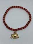 Red bracelet with dangling gold elephant