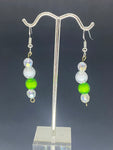 White pearls with one green pearl earring