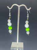 White pearls with one green pearl earring