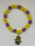  Dangling shiny gold hand with yellow and purple bead bracelet