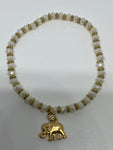 White and gold bracelet with dangling gold elephant