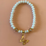 White bracelet with gold dangling butterfly